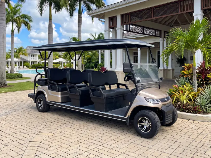 Carrito de golf eléctrico ECO Cross 6+2 de ocho plazas estacionado en la entrada de un resort
