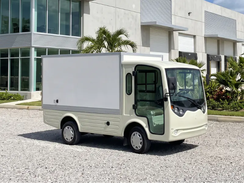 Vehículo de carga eléctrico ECO E-Cargo Box con caja cerrada frente a un almacén