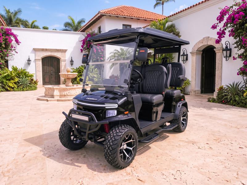 Denago Rover XL four-seat electric golf cart in black in the courtyard of a whitewashed Spanish colonial villa with a stone fountain and bougainvillea in Casa de Campo