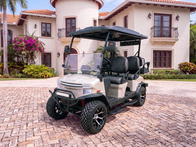 Denago Rover XL6 six-seat electric golf cart in champagne on a stone driveway in front of a Spanish revival villa with a round tower and wrought iron balconies in Casa de Campo