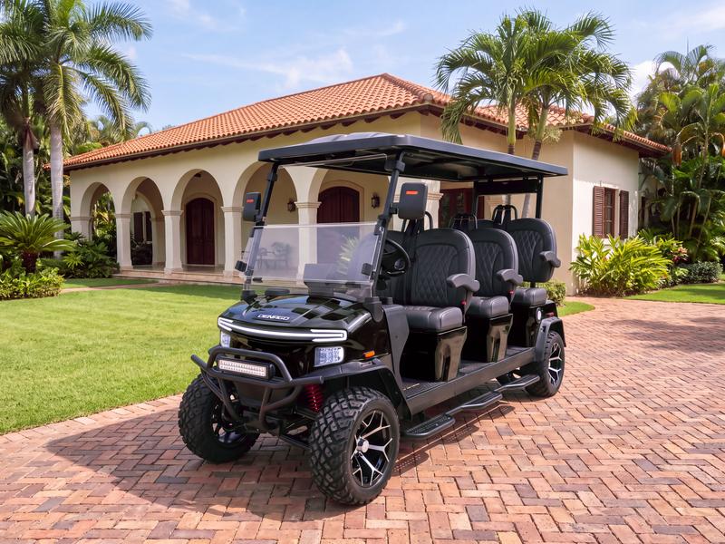 Denago Rover XXL six-seat electric golf cart in black on a brick driveway in front of an arched colonial villa in Casa de Campo