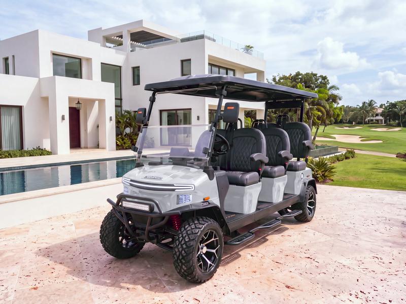 Denago Rover XXL six-seat electric golf cart in grey beside the pool of a modern white villa on the golf course in Casa de Campo
