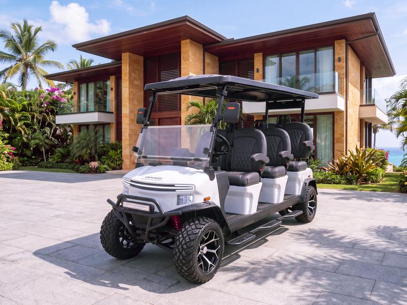Denago Rover XXL six-seat electric golf cart in white in front of a modern coral stone villa in Casa de Campo