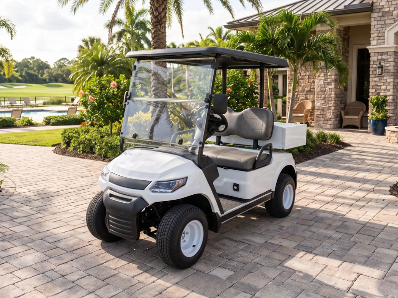 ECO Cross 2 Cargo S white two-seat electric golf cart with a small rear cargo box on a paved driveway