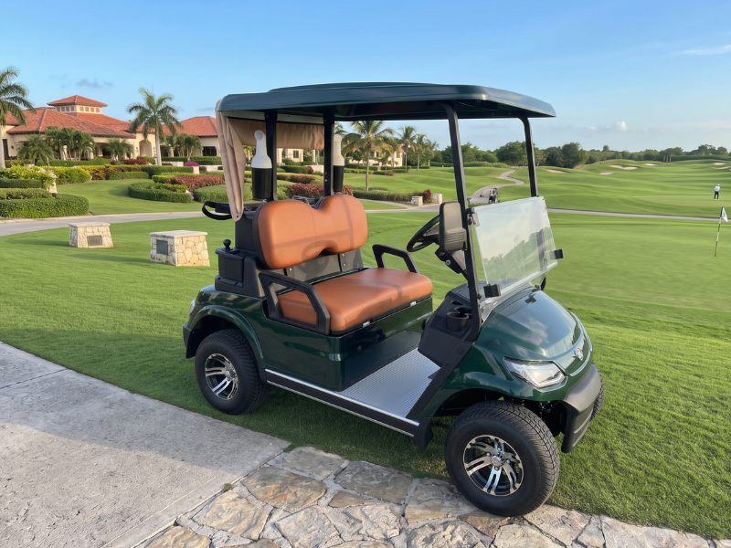ECO Cross 2 two-seat green electric golf cart with tan seats beside a golf course fairway