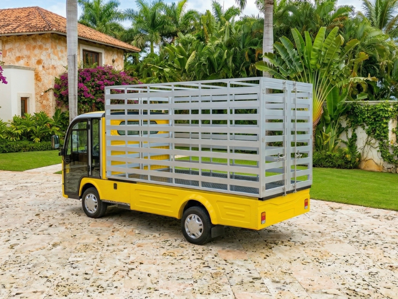 ECO E-Cargo Laundry yellow electric vehicle with tall aluminium slatted cage body on a resort driveway